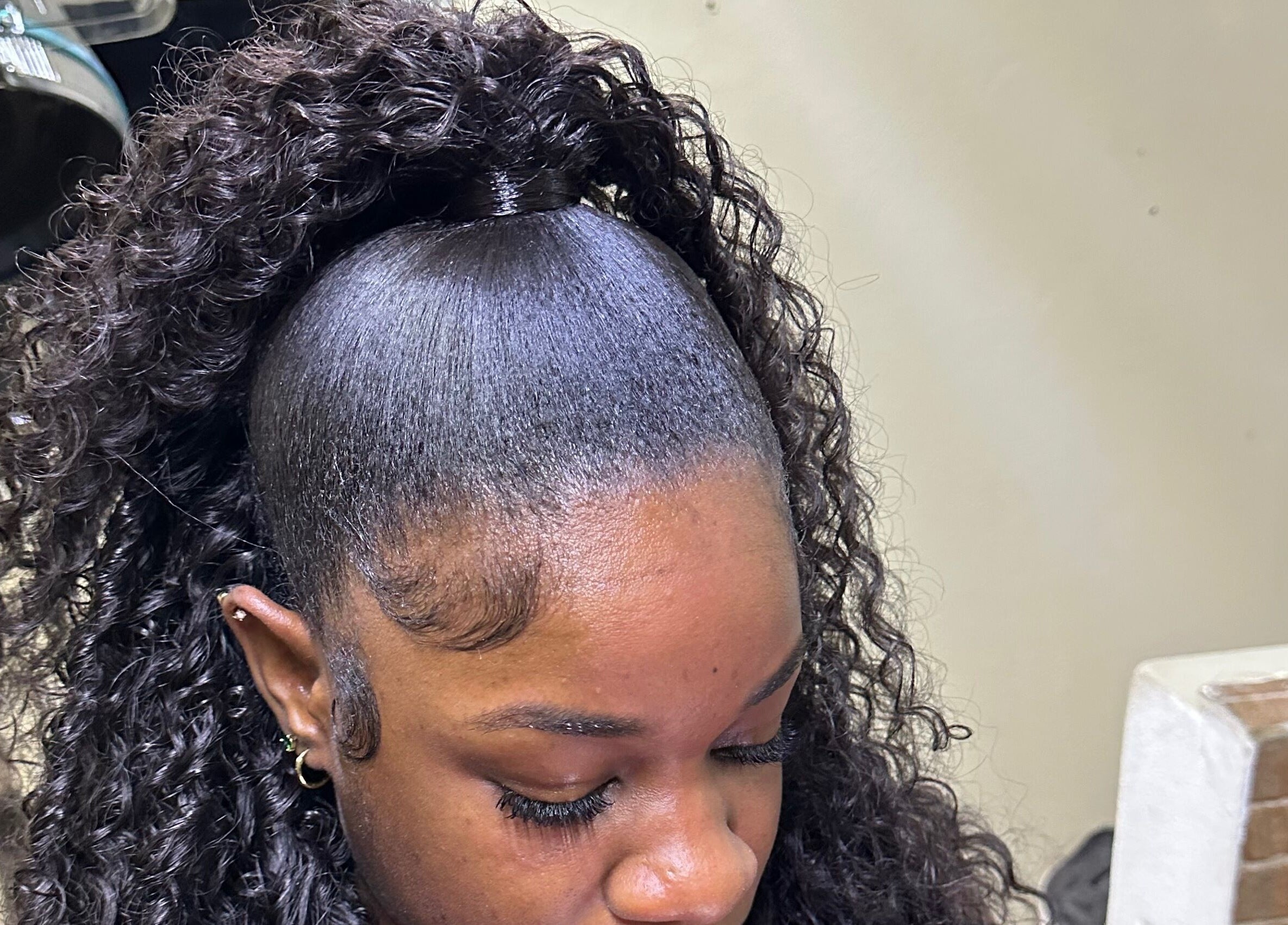 Woman with a sleek curly hairstyle at Beauti Cabin, Kingston, St. Andrew Parish, JM.
