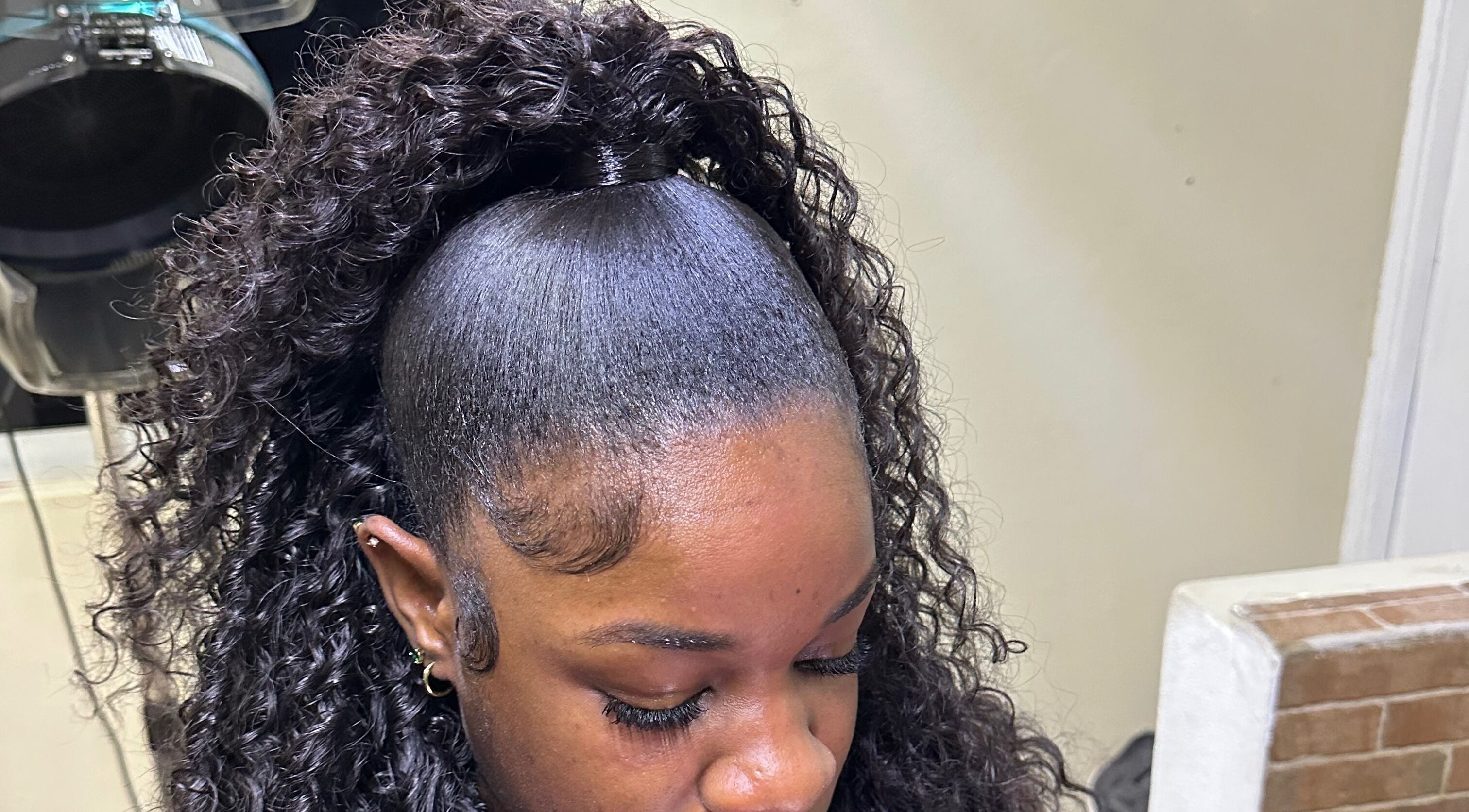 Woman with a sleek curly hairstyle at Beauti Cabin, Kingston, St. Andrew Parish, JM.