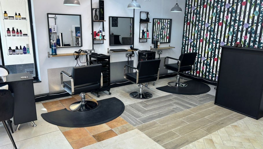 Modern salon seating area at Lisa's Hair Emporium, Bude, England, GB featuring stylish black chairs.