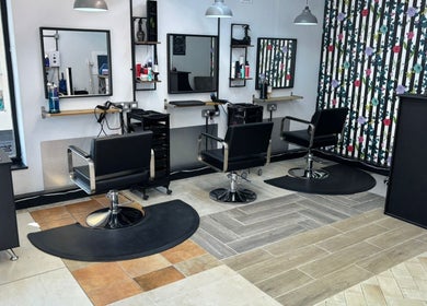 Modern salon seating area at Lisa's Hair Emporium, Bude, England, GB featuring stylish black chairs.