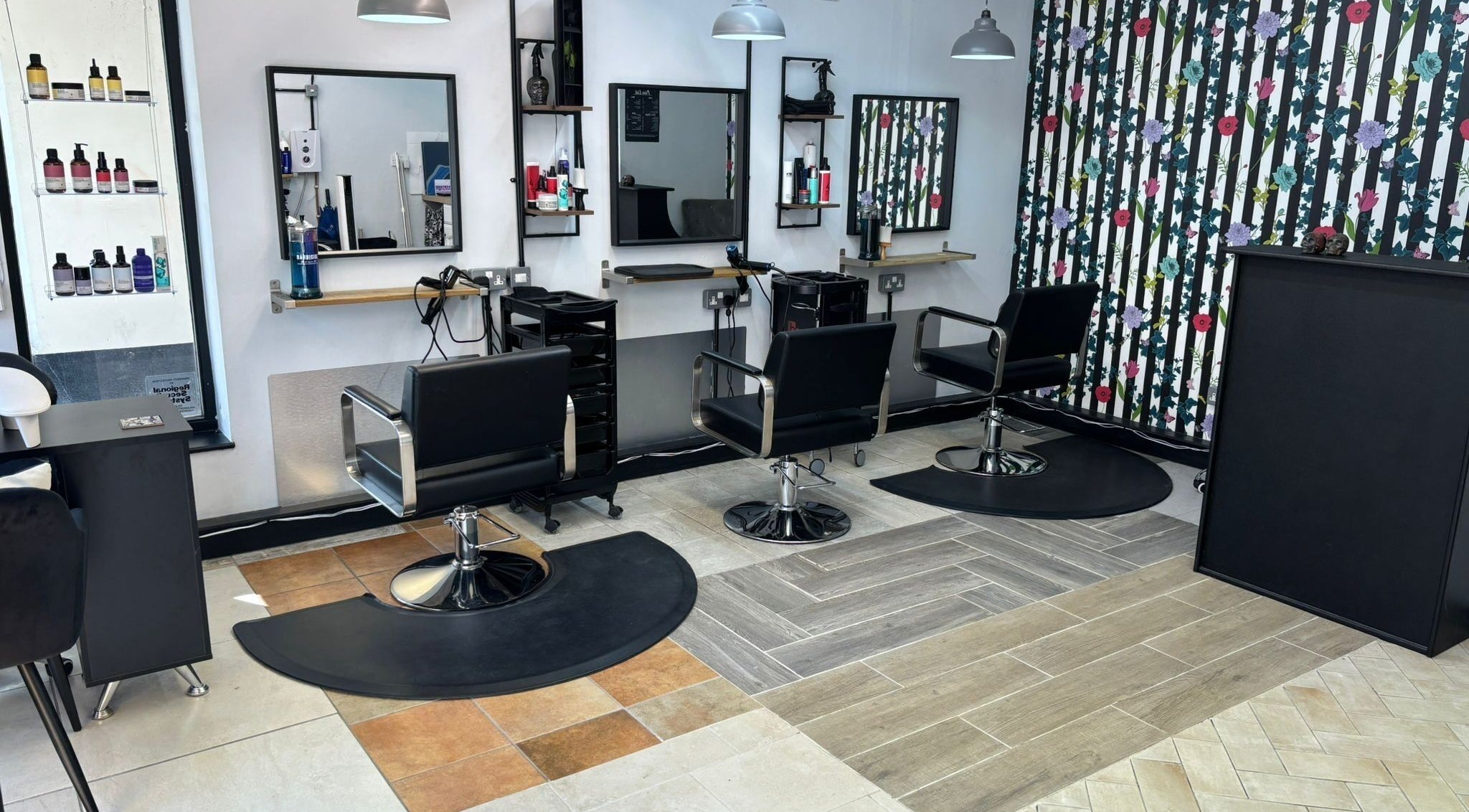 Modern salon seating area at Lisa's Hair Emporium, Bude, England, GB featuring stylish black chairs.