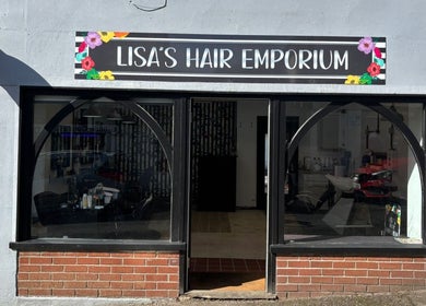 Front view of Lisa's Hair Emporium in Bude, England showcasing stylish entrance and vibrant signage.