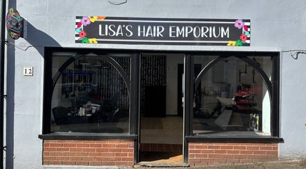 Front view of Lisa's Hair Emporium in Bude, England showcasing stylish entrance and vibrant signage.