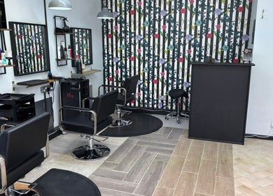 Elegant interior of Lisa's Hair Emporium in Bude, England, GB with stylish salon chairs and floral decor.