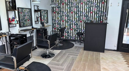 Elegant interior of Lisa's Hair Emporium in Bude, England, GB with stylish salon chairs and floral decor.