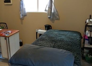 Tranquil treatment room at Sakura Beauty by Tarryn, East London, Eastern Cape, ZA featuring a cozy bed and desk.