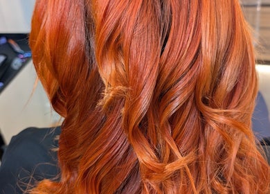 Vibrant red-orange hair styled in waves at Twisted Friction @ Strands Studio, Sheffield, England, GB.
