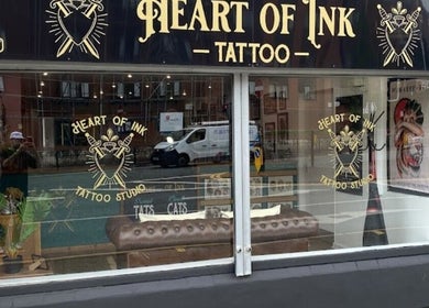 Loz The Hat Tattoo And Piercing's artistic windowfront in Ashton-in-Makerfield, England displays their unique style.