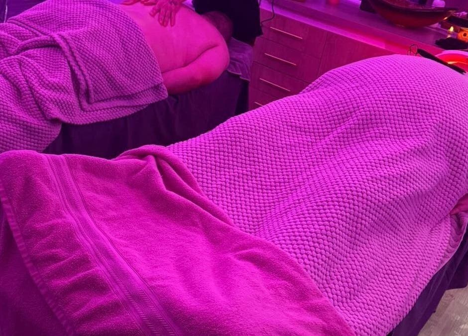 Relaxing massage setup at Eden Hair & Beauty, Heywood, England, GB under calming purple lighting.