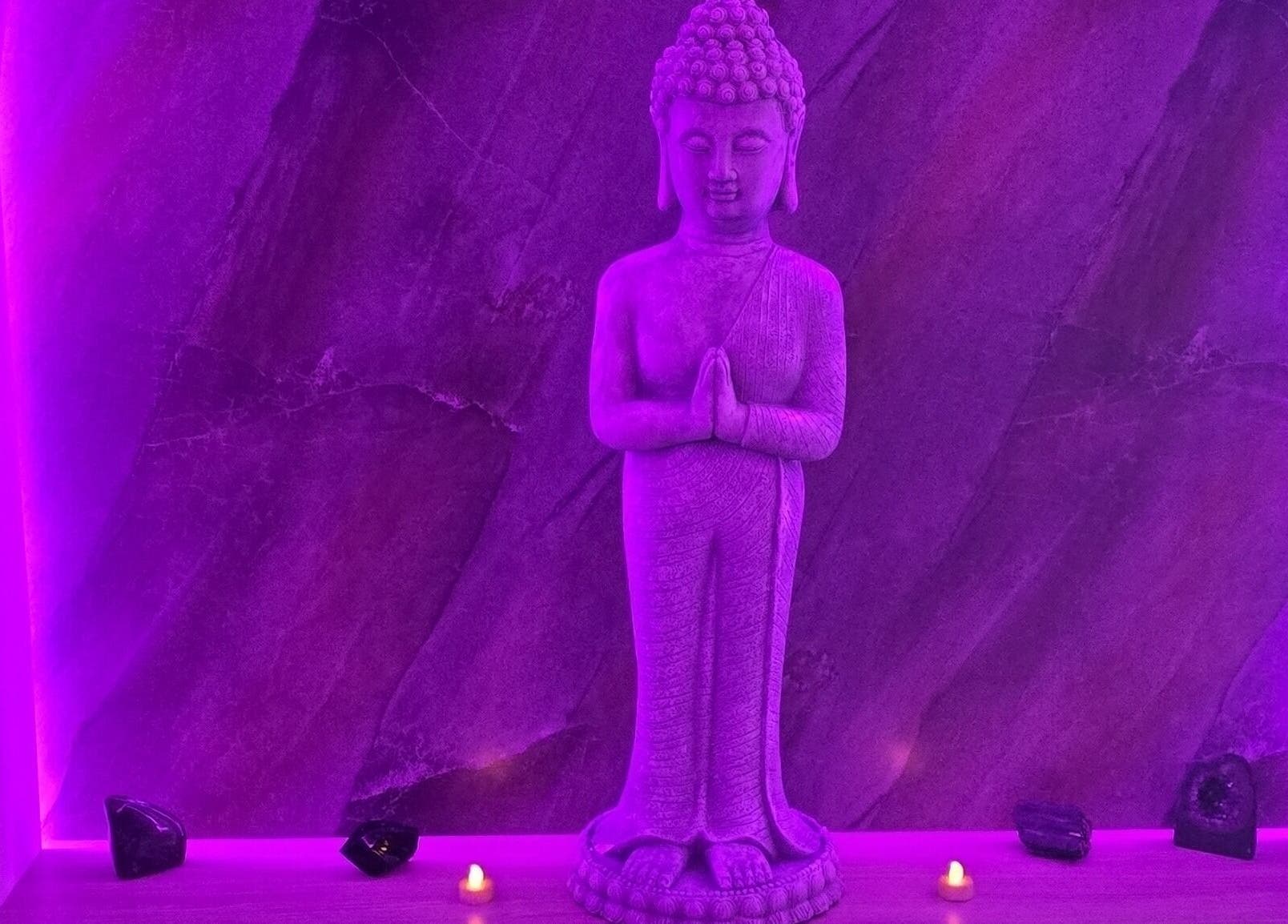 Serene Buddha statue under purple light at Eden Hair & Beauty, Heywood, England, GB. Tranquil spa ambiance.