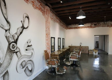 Interior of Blade Cartel Barber and Aesthetics, Bunbury, featuring artistic wall and vintage chairs.