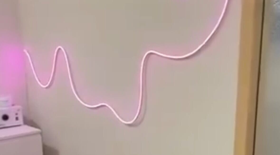Pink neon wave decor on wall at Aesthetician Mariana, New Westminster, British Columbia, CA.