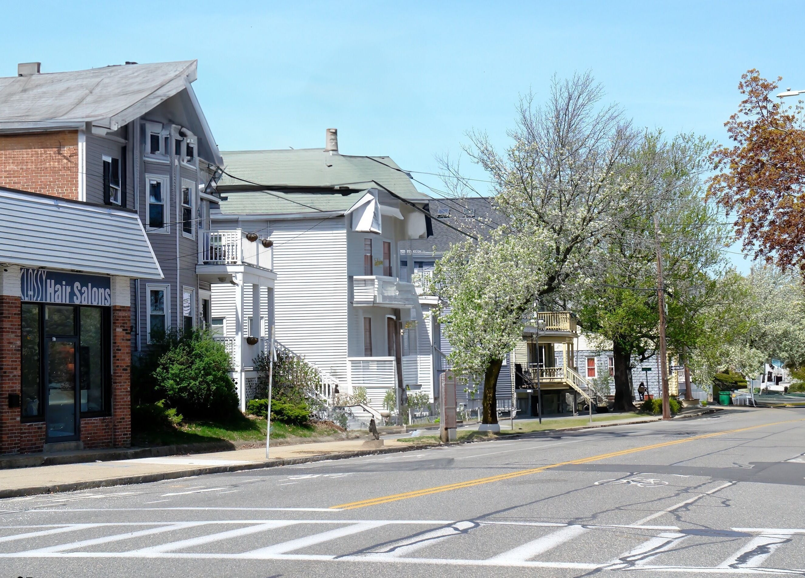 Exterior of Shape Nails Medford on a sunny street in Medford, Massachusetts, US, with nearby businesses.