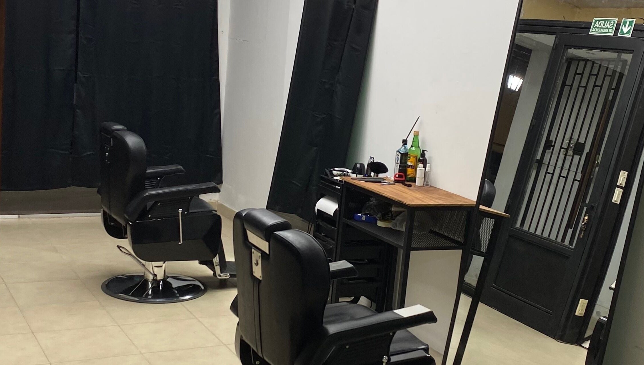 Interior moderno de Chilax Barber Shop en Merlo, San Luis, AR con sillas negras y estación de trabajo.