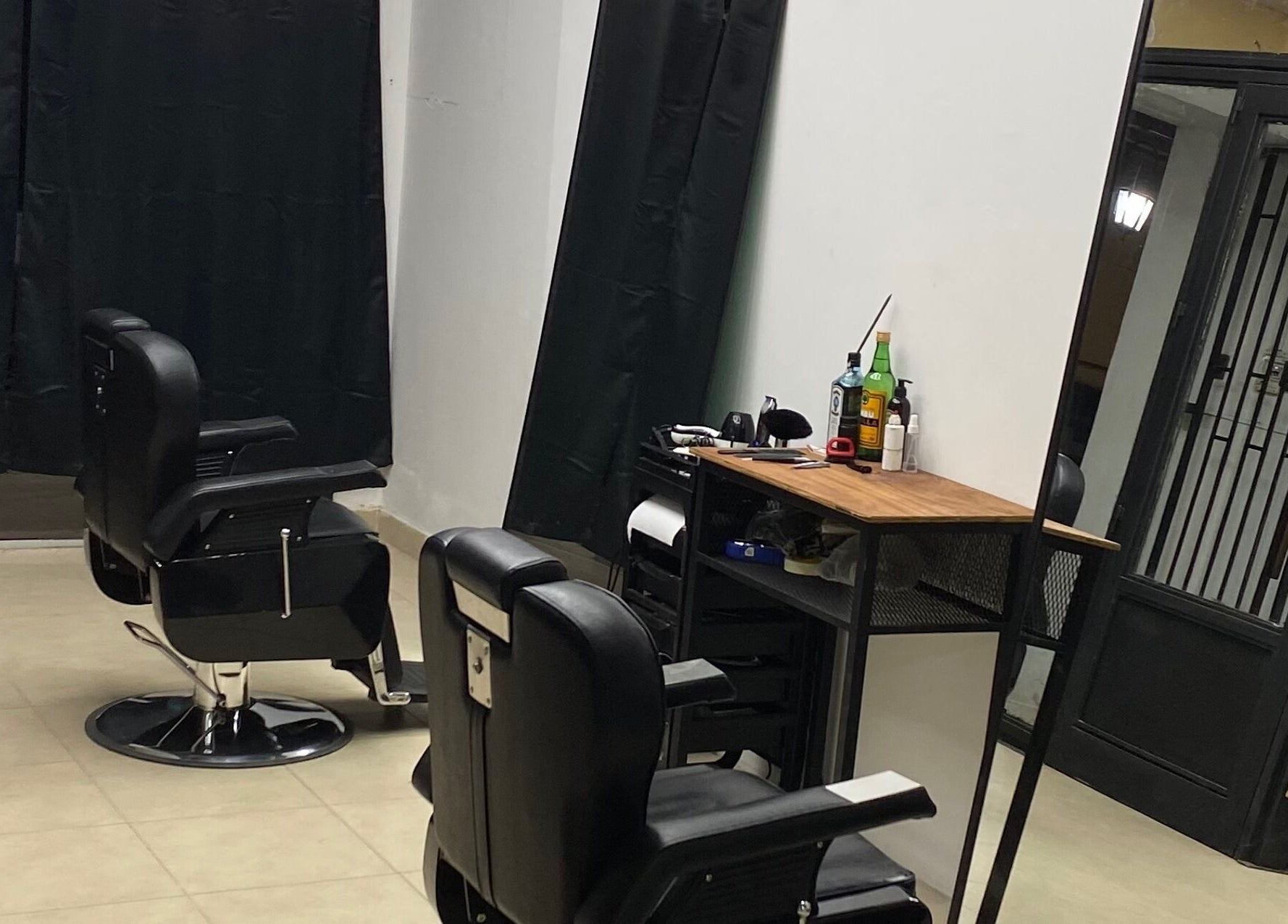 Interior moderno de Chilax Barber Shop en Merlo, San Luis, AR con sillas negras y estación de trabajo.