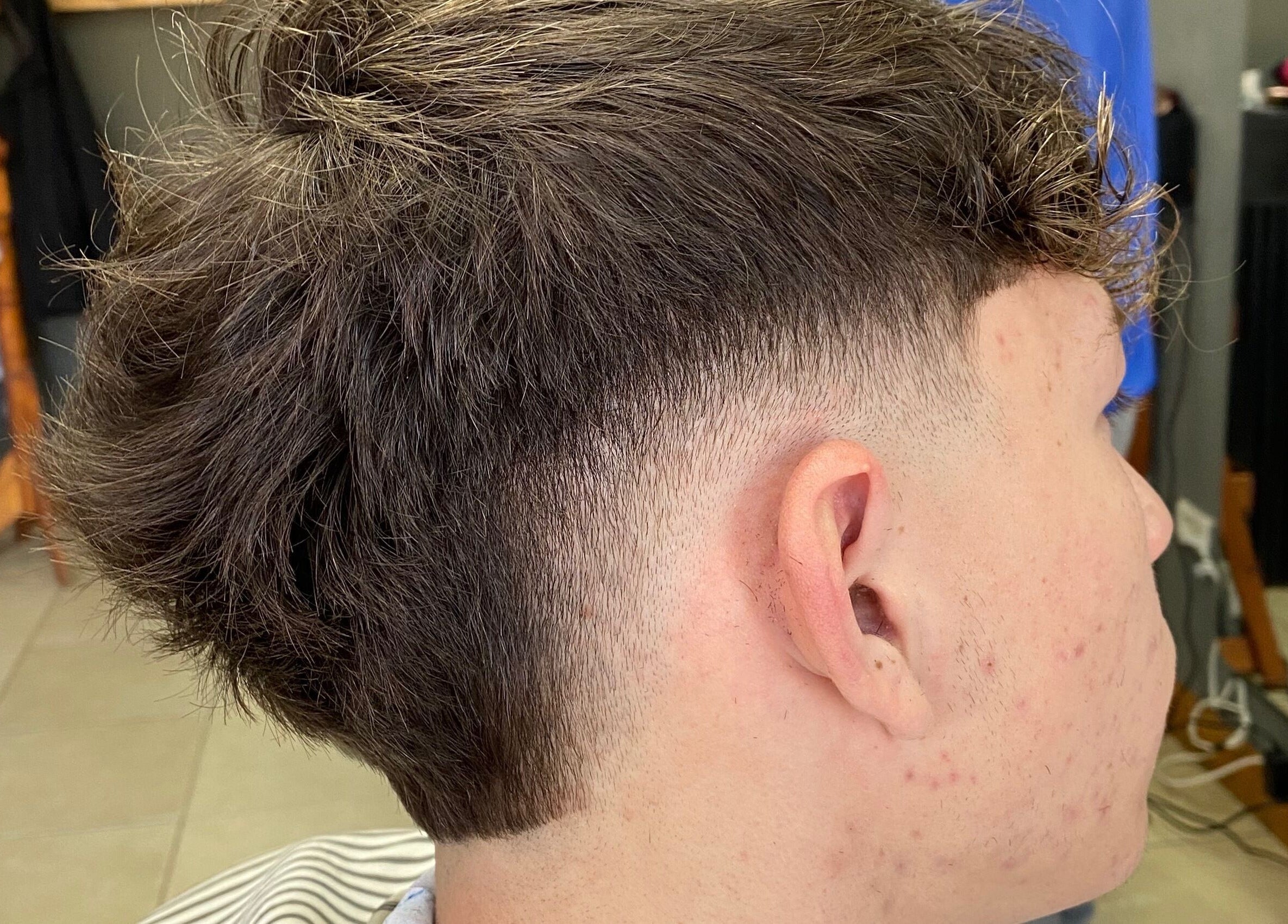 Moderno corte de cabello en Chilax Barber Shop, Merlo, San Luis, AR, destacando técnica de desvanecido.