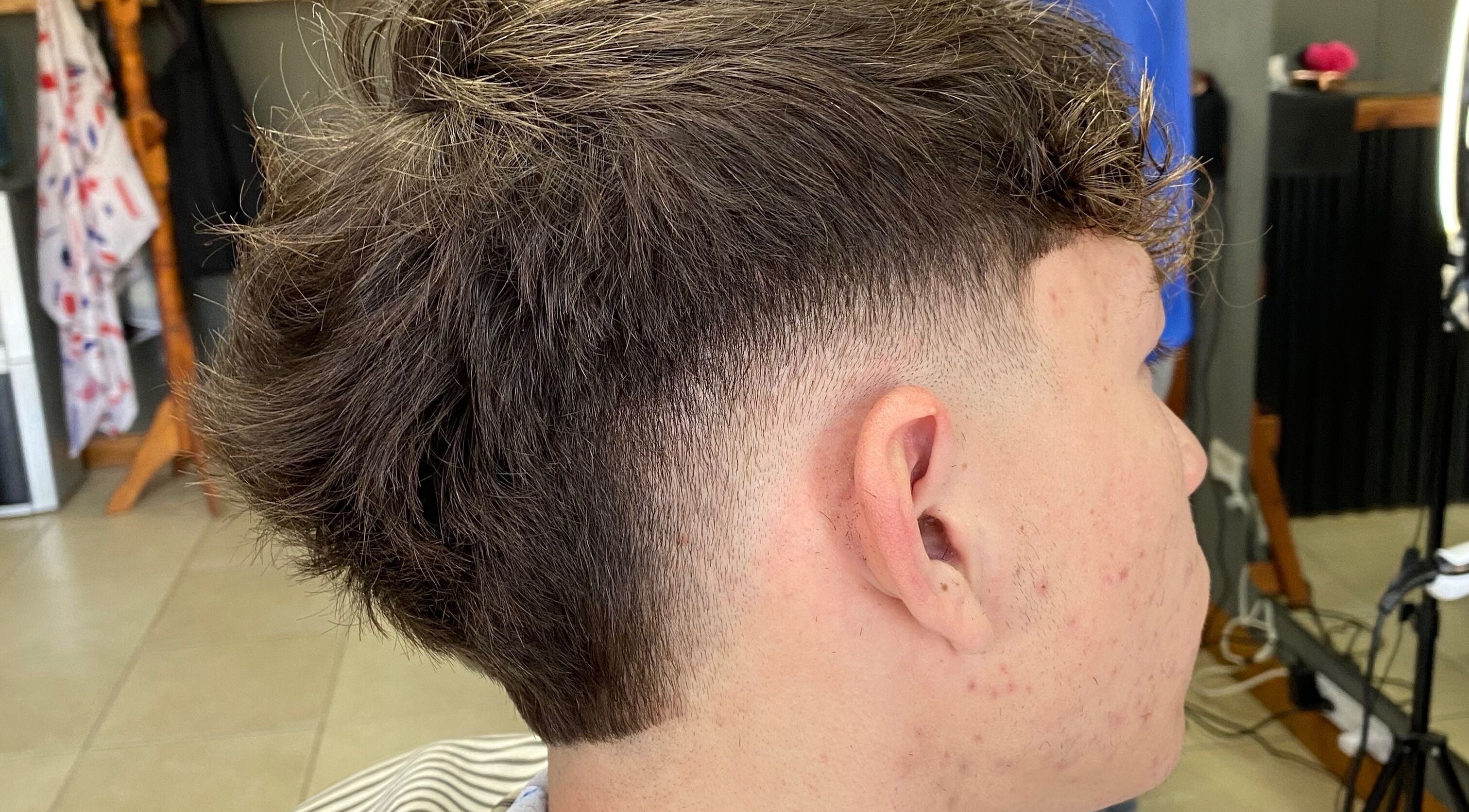 Moderno corte de cabello en Chilax Barber Shop, Merlo, San Luis, AR, destacando técnica de desvanecido.