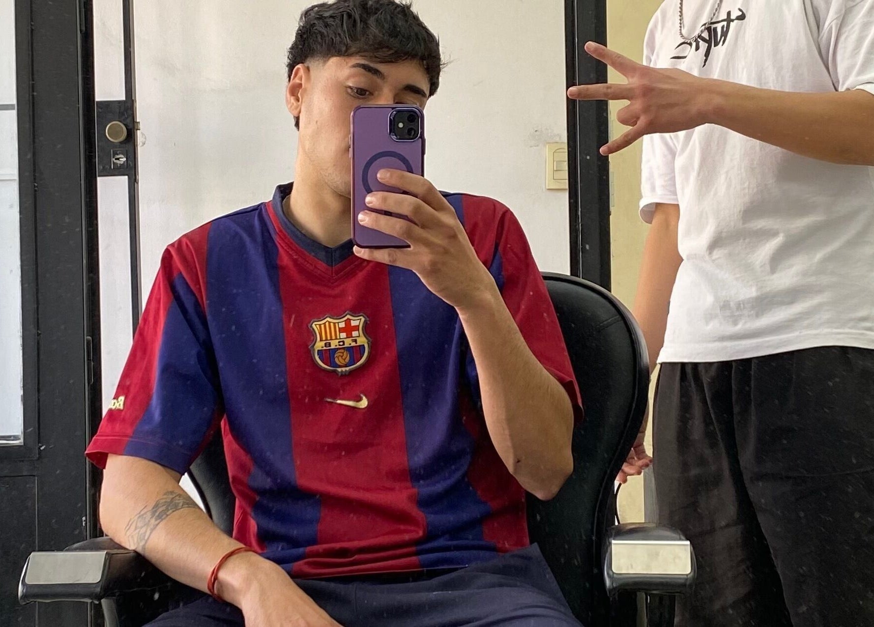 Cliente en Chilax Barber Shop, Merlo, San Luis, AR, con corte fresco y camisa de fútbol.