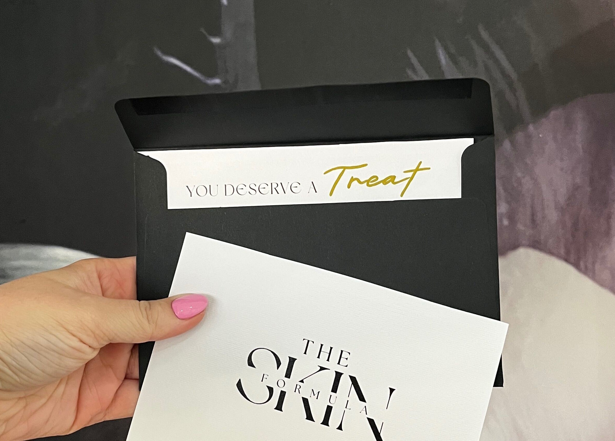 Hand holding The Skin Formula card in Cape Town, Western Cape, ZA. Text reads 'You deserve a treat'.