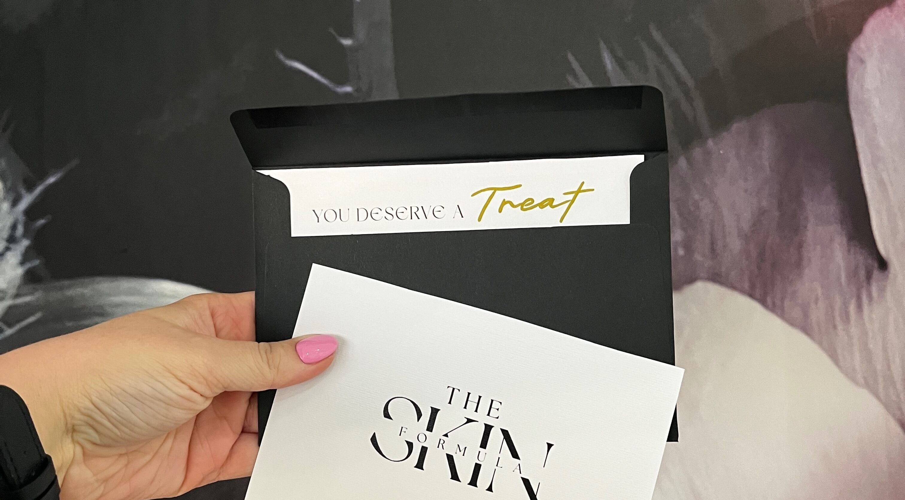 Hand holding The Skin Formula card in Cape Town, Western Cape, ZA. Text reads 'You deserve a treat'.