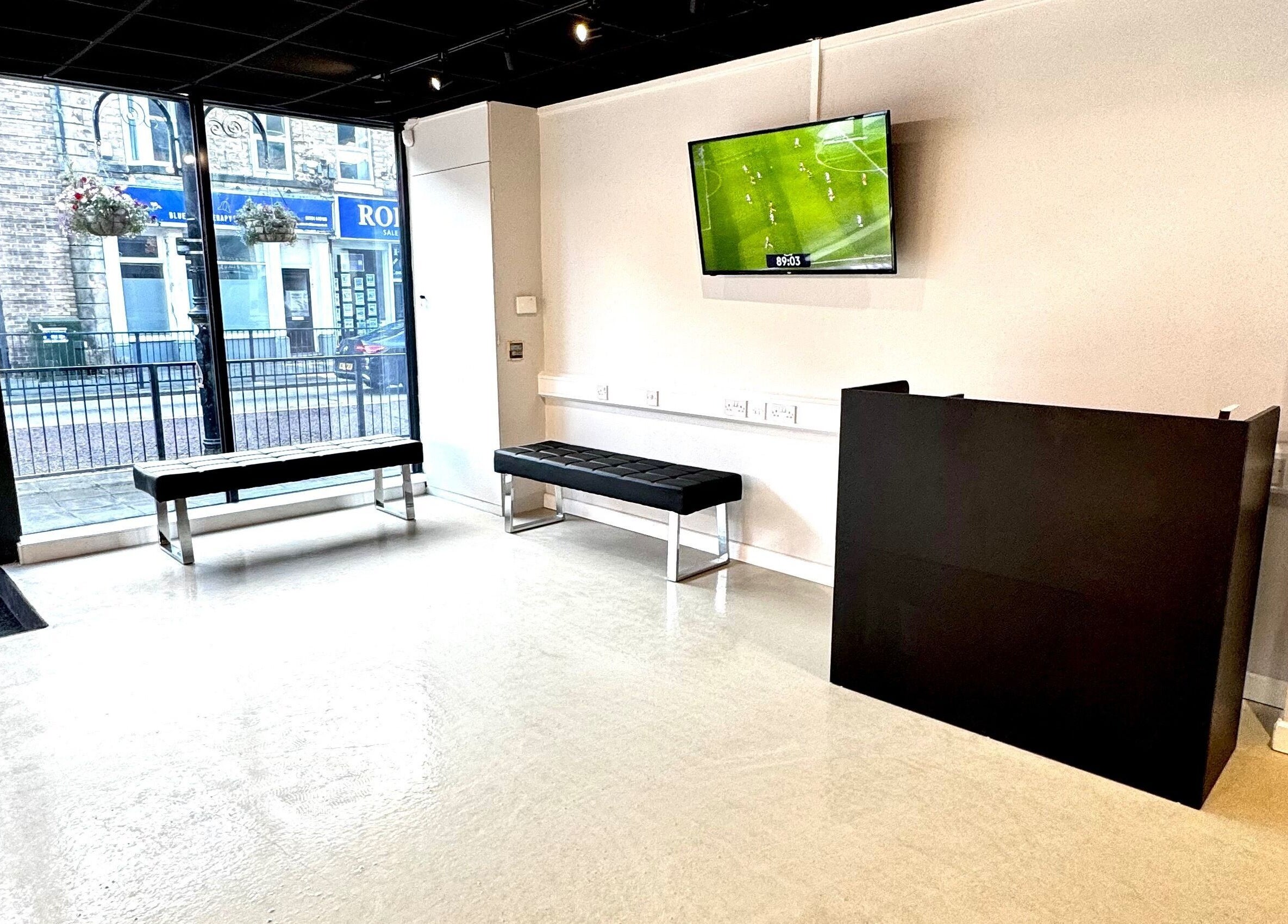 Modern waiting area at Simply Rogue Bishop Auckland in Bishop Auckland, England, GB with stylish seating and TV.