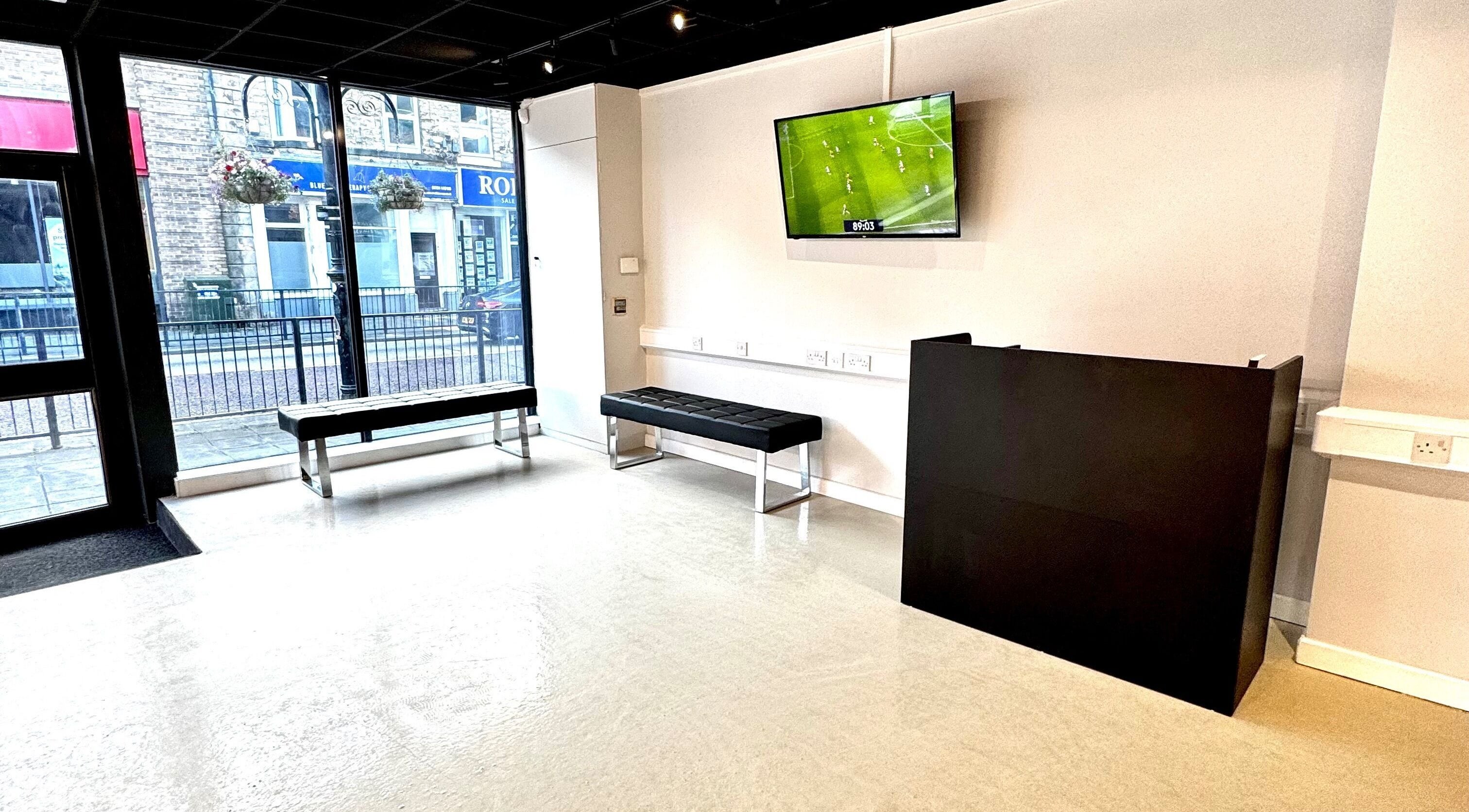 Modern waiting area at Simply Rogue Bishop Auckland in Bishop Auckland, England, GB with stylish seating and TV.