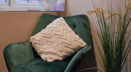 Relaxing green chair with a textured pillow at Aster Beauty, Fakenham, England, GB.