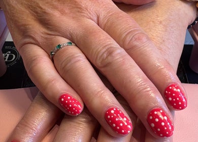 Elegant red polka-dot nail art at Aster Beauty, Fakenham, England, GB, showcasing polished creativity.