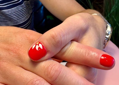 Stylish red manicure with floral design at Aster Beauty, Fakenham, England, GB.