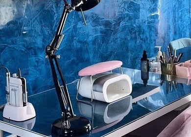 Modern nail station at Alexander Beauty and Training Academy in Irvine, Scotland, GB, featuring tools and a lamp.
