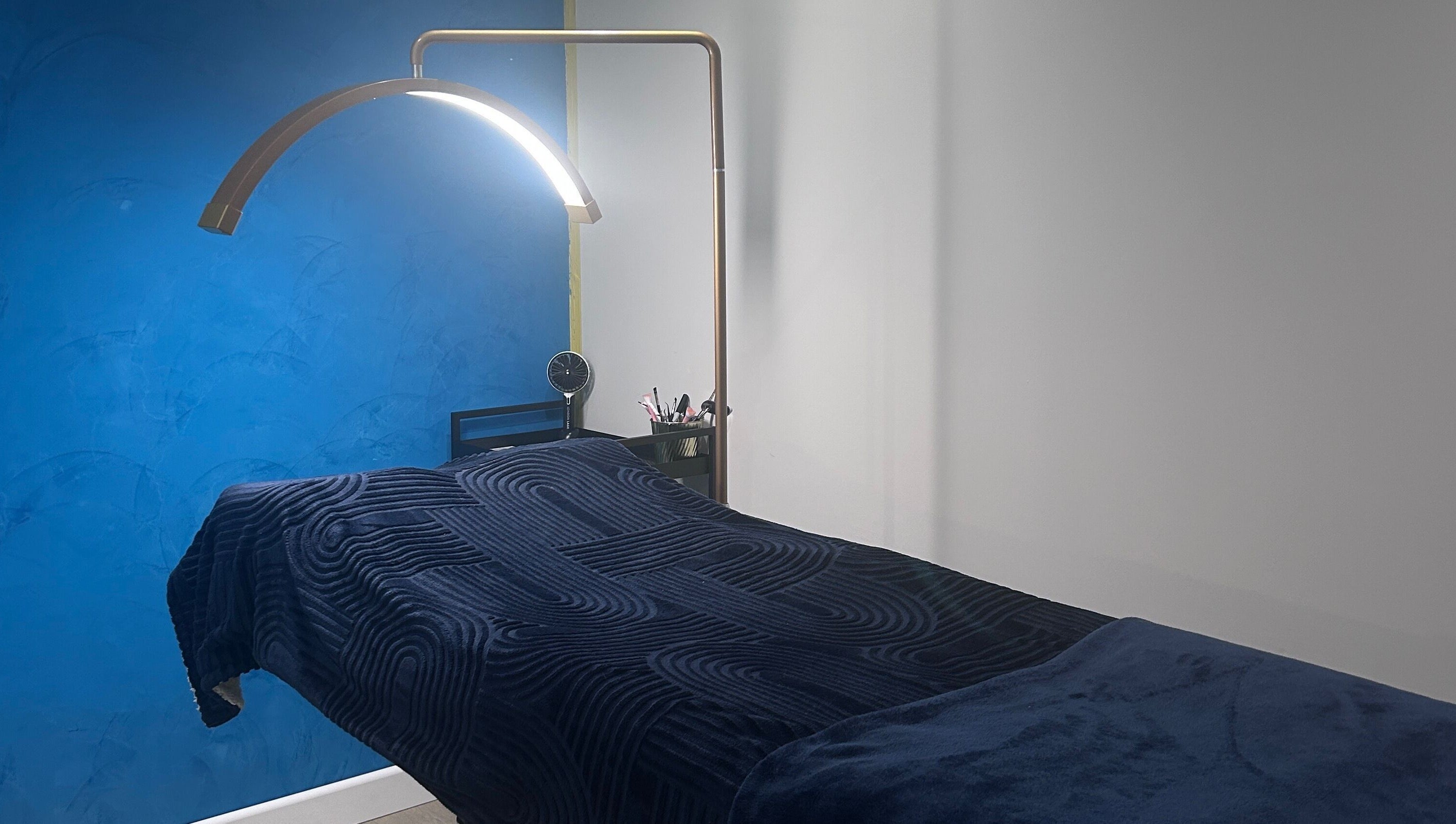 Relaxing treatment room at Alexander Beauty and Training Academy, Irvine, Scotland, GB with modern decor and ambient lighting.