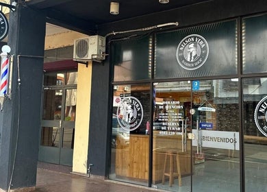 Fachada de Nelson Vera Barber Shop en Encarnación, Itapúa, PY mostrando logotipo y entrada.
