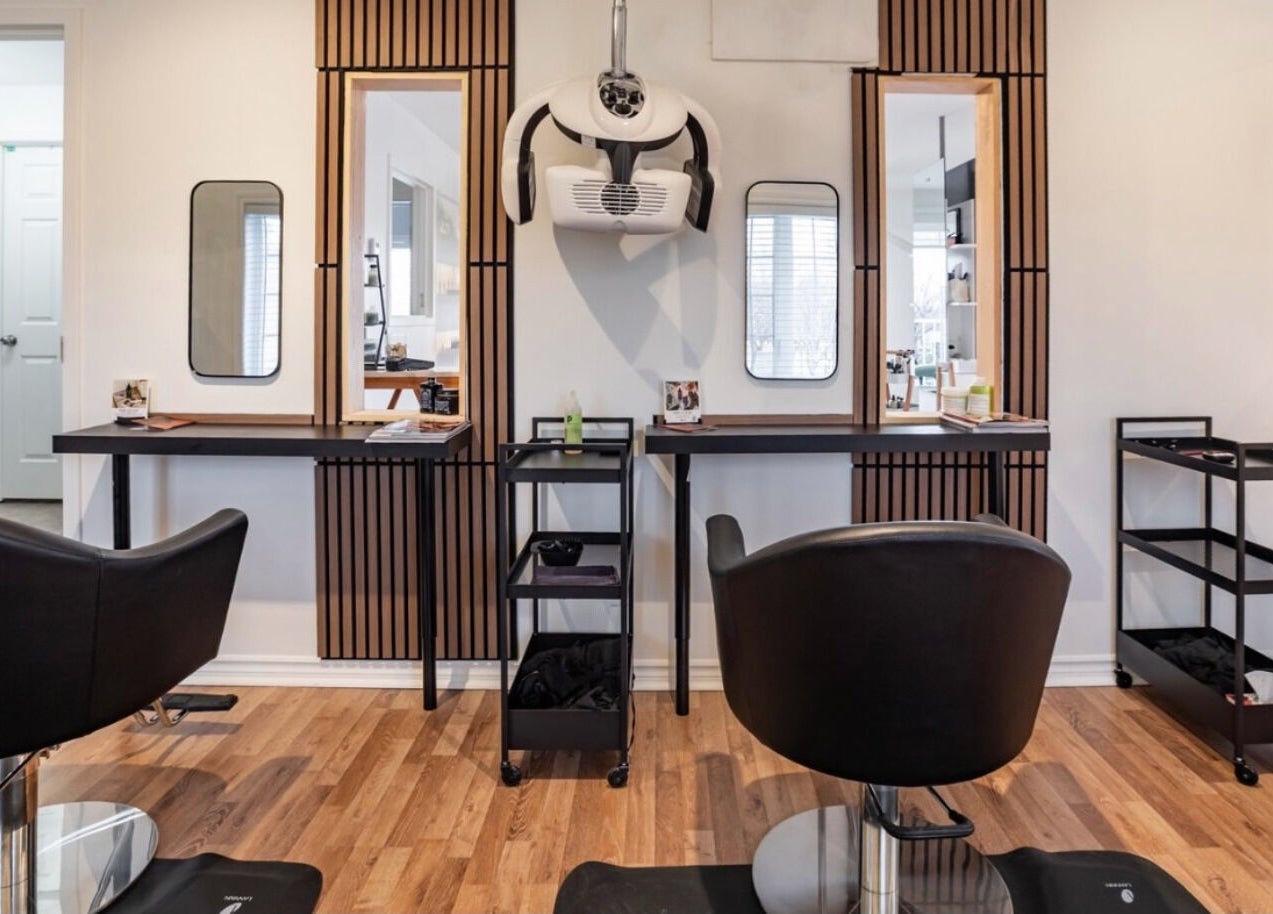 Intérieur chic du salon Village Coiffure à Saint-Basile-le-Grand, Québec, CA avec espaces stylés.