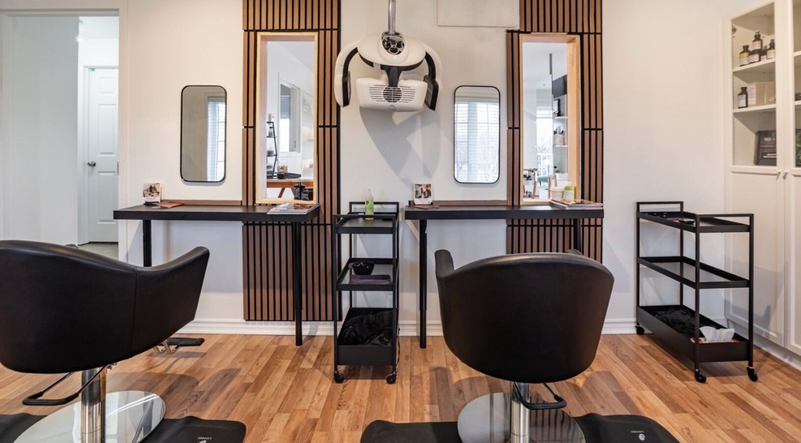 Intérieur chic du salon Village Coiffure à Saint-Basile-le-Grand, Québec, CA avec espaces stylés.