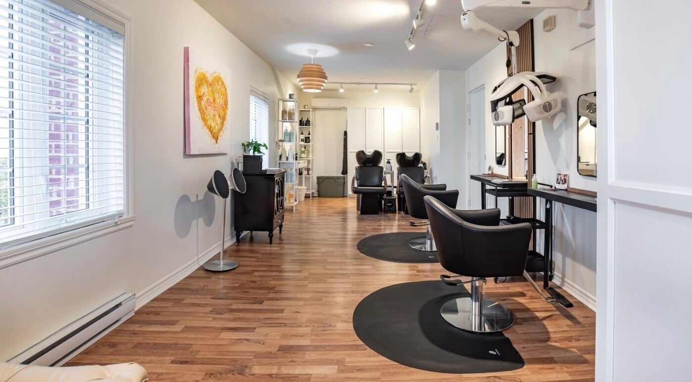 Intérieur élégant de Village Coiffure à Saint-Basile-le-Grand, Québec, CA avec chaises modernes et décor chaleureux.
