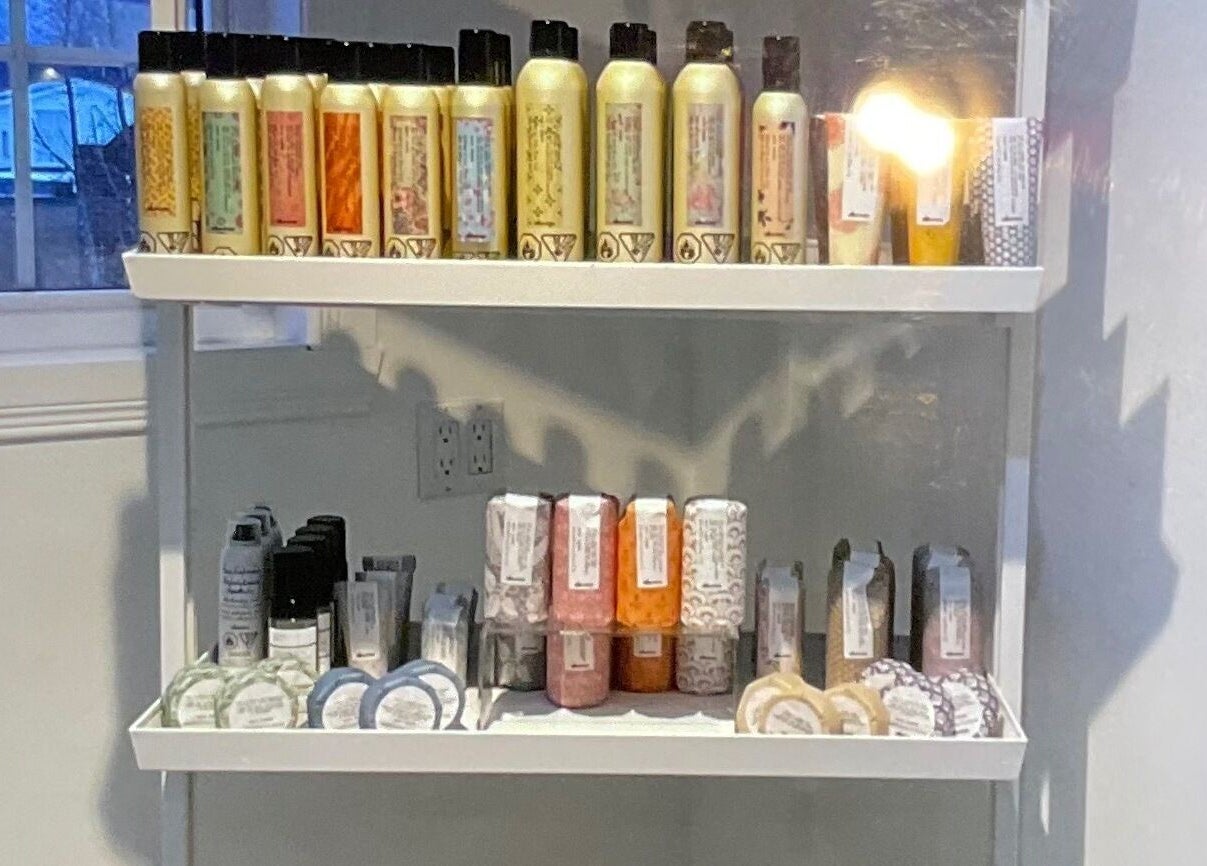 Produits de soins sur une étagère chez Village Coiffure à Saint-Basile-le-Grand, Québec, CA.