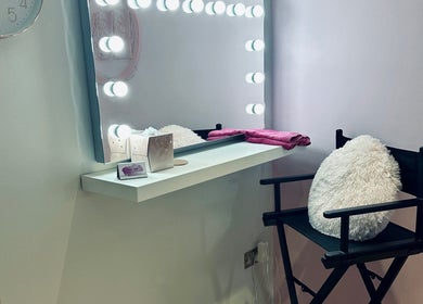 Makeup vanity with mirror lights at Lux by Kristina, Cheltenham, England, GB. Elegant setup with chair and decor.