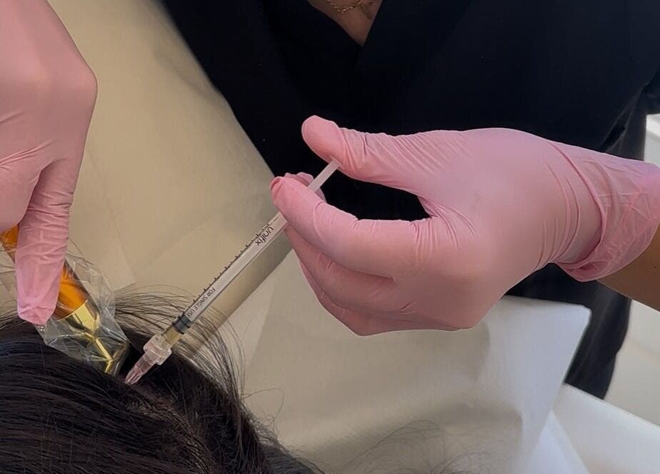 Hair treatment at Ethereal Aesthetics, London, England, GB. Close-up of skilled hands providing hair service.