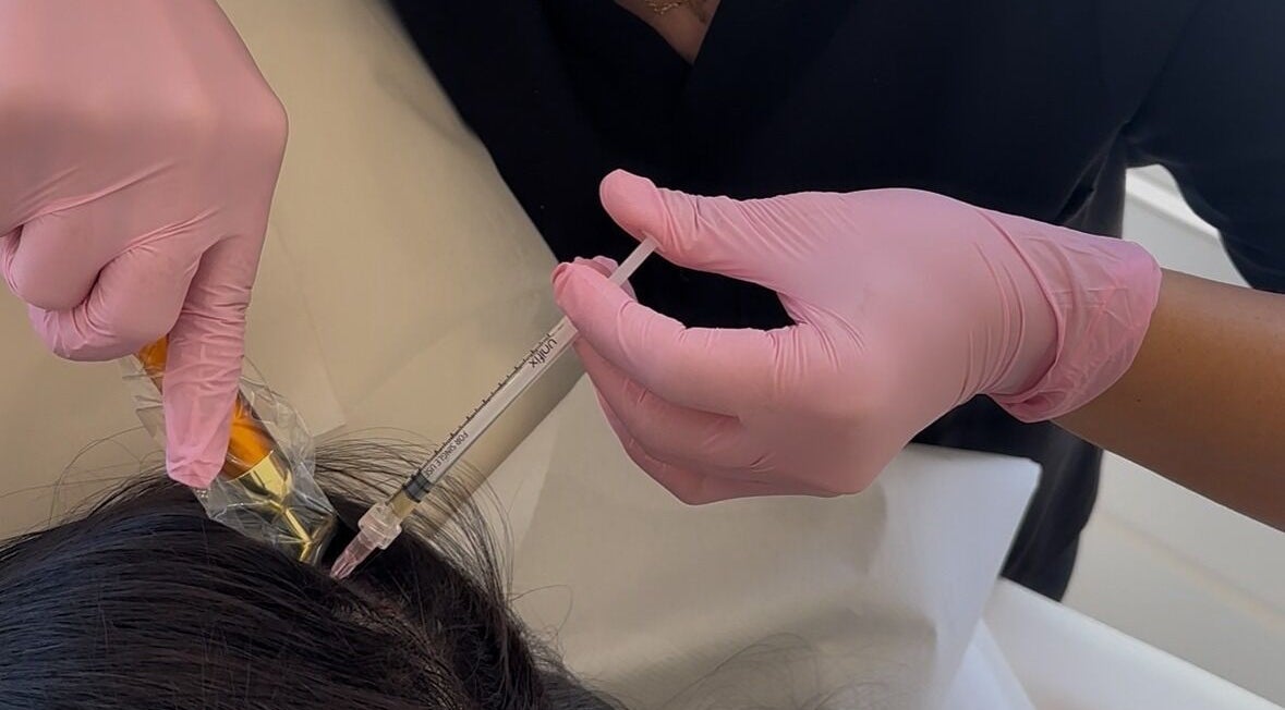 Hair treatment at Ethereal Aesthetics, London, England, GB. Close-up of skilled hands providing hair service.