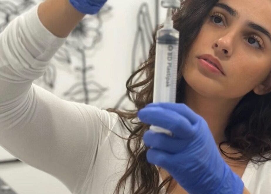 Skilled aesthetician at Ethereal Aesthetics in London, England, GB preparing a syringe with precision.