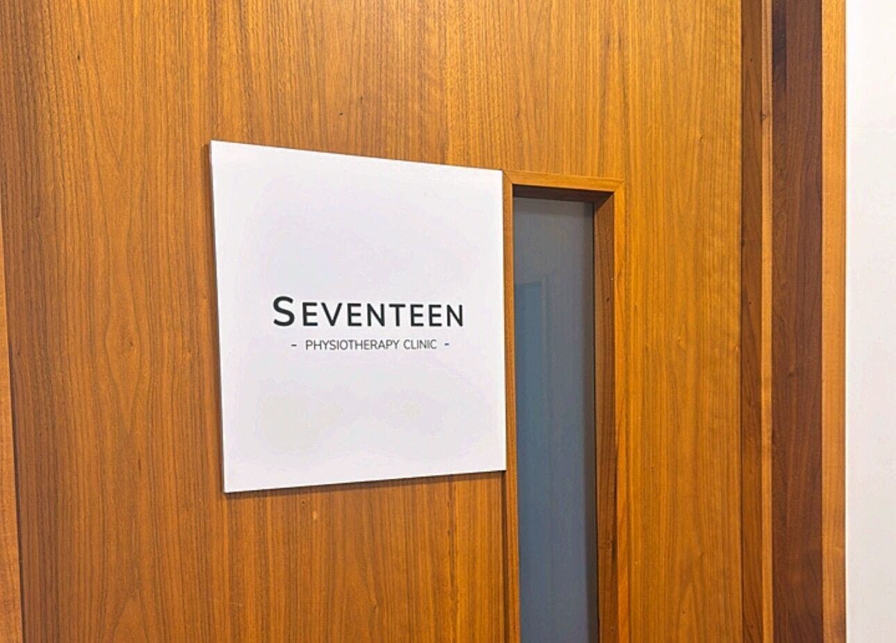 Seventeen Physiotherapy Clinic entrance sign in London, England, GB, with wooden background.