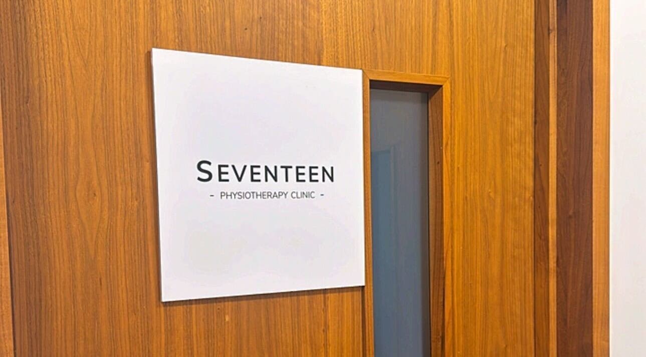 Seventeen Physiotherapy Clinic entrance sign in London, England, GB, with wooden background.