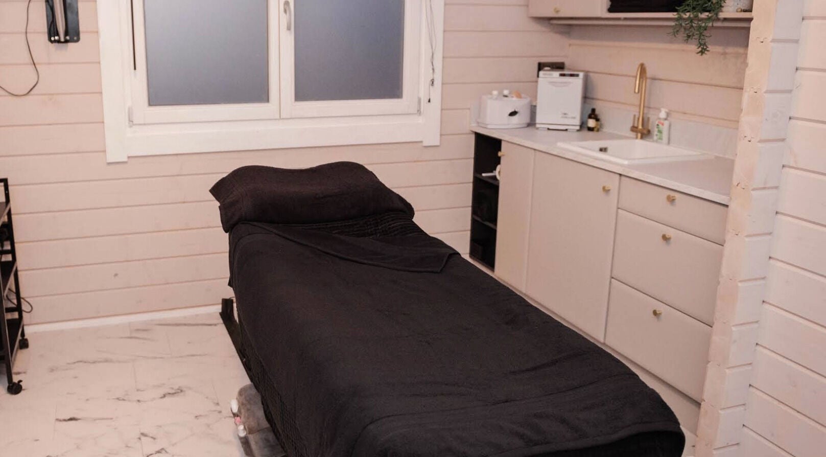 Cozy therapy room at Unico in Kelso, Scotland, GB with a black massage bed and modern decor.