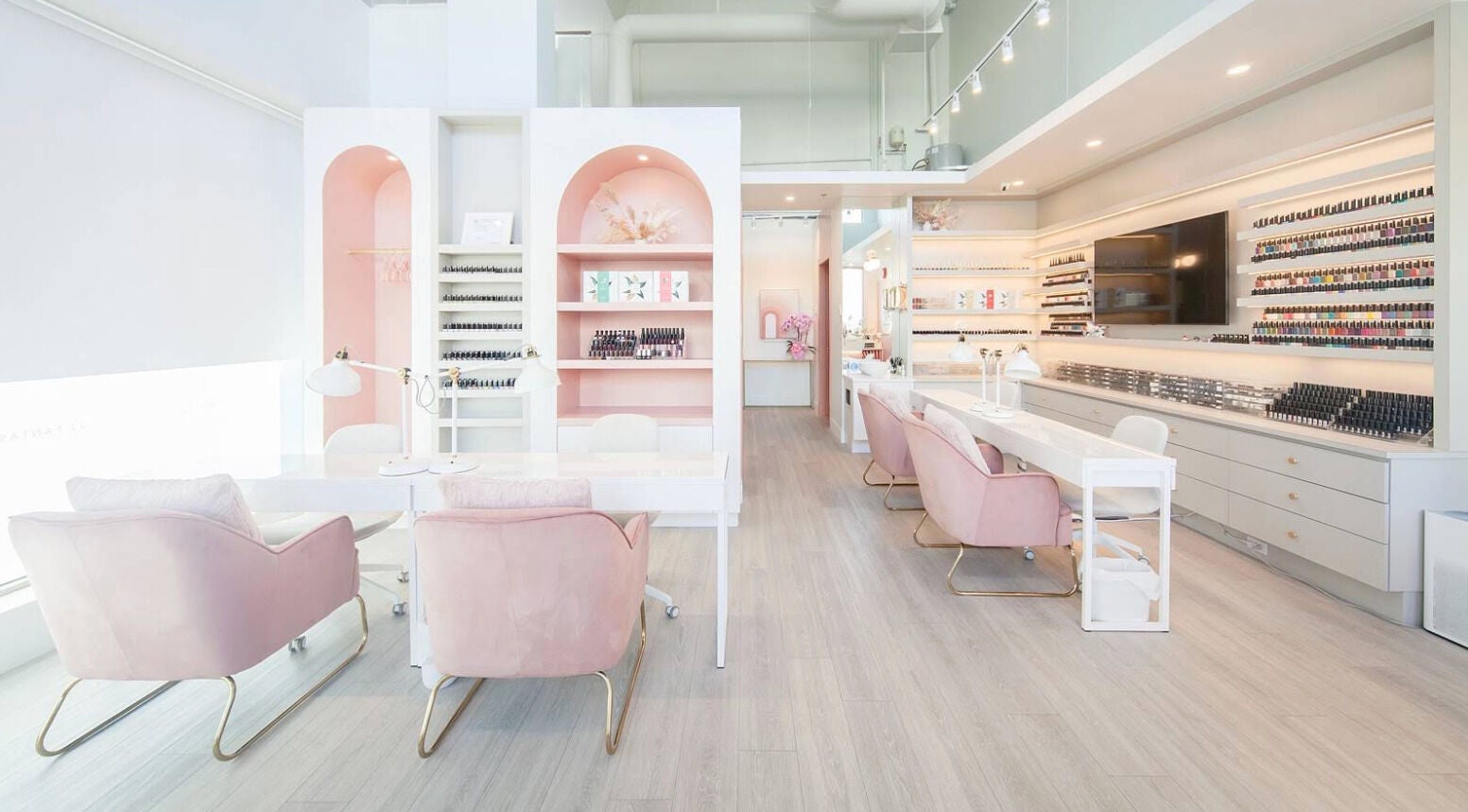 Chic nail salon at JJ Fantasy World, Richmond, British Columbia, CA featuring pink chairs and polish displays.