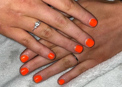 Bright orange manicure showcasing nail artistry at Khloes Beauty Room, Belfast, Northern Ireland, GB.