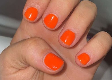 Bright orange manicure at Khloes Beauty Room, Belfast, Northern Ireland, GB, showcasing stunning nail art.