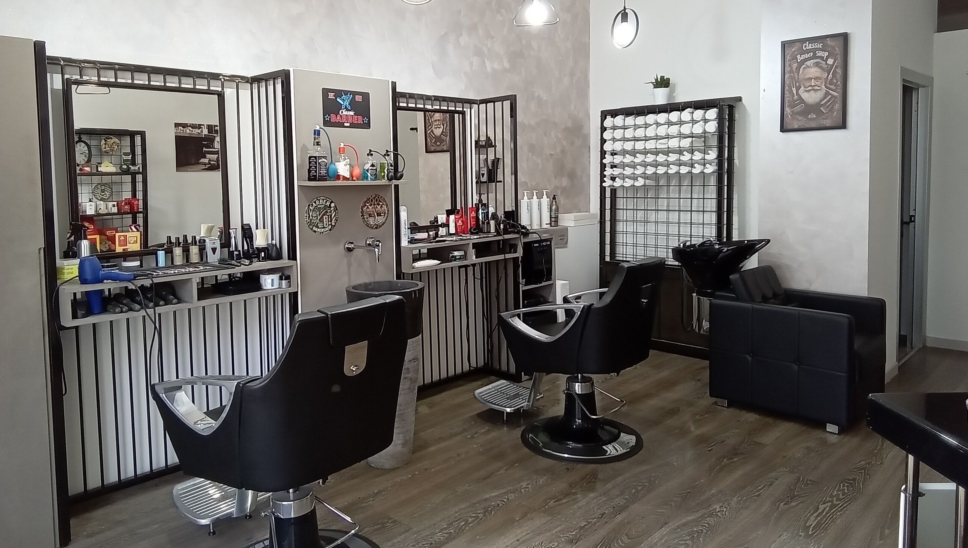 Interno elegante di Classic Barber, San Vittore Olona, Lombardia, IT con poltrone e accessori.