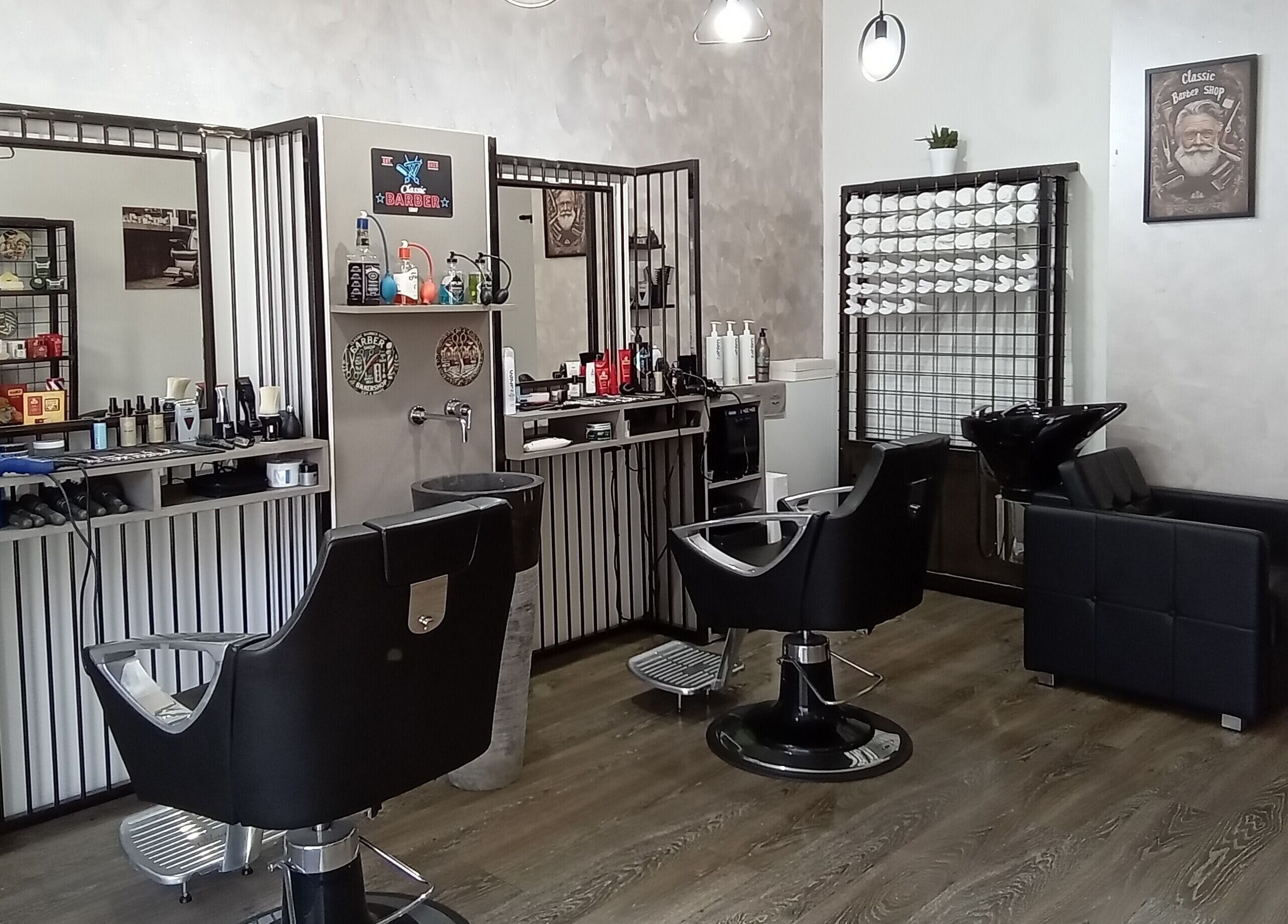 Interno elegante di Classic Barber, San Vittore Olona, Lombardia, IT con poltrone e accessori.