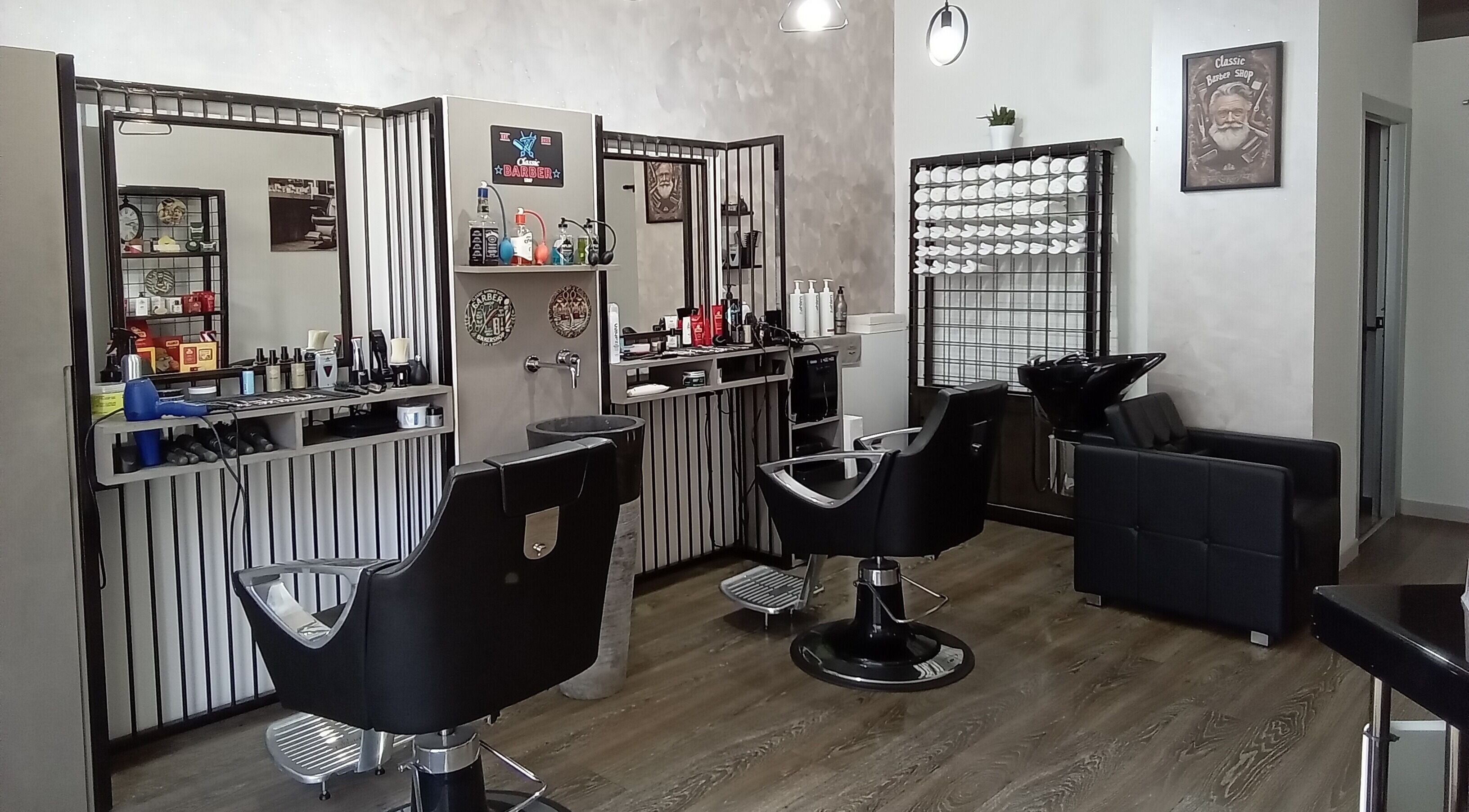 Interno elegante di Classic Barber, San Vittore Olona, Lombardia, IT con poltrone e accessori.
