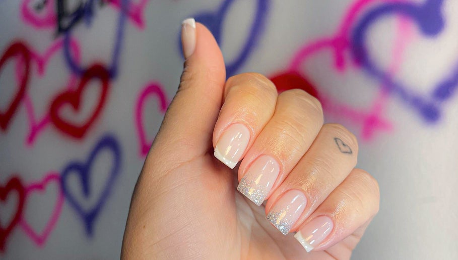 Unhas elegantes com glitter e fundo colorido de corações no Espaço Linikher, São Paulo, São Paulo, BR.